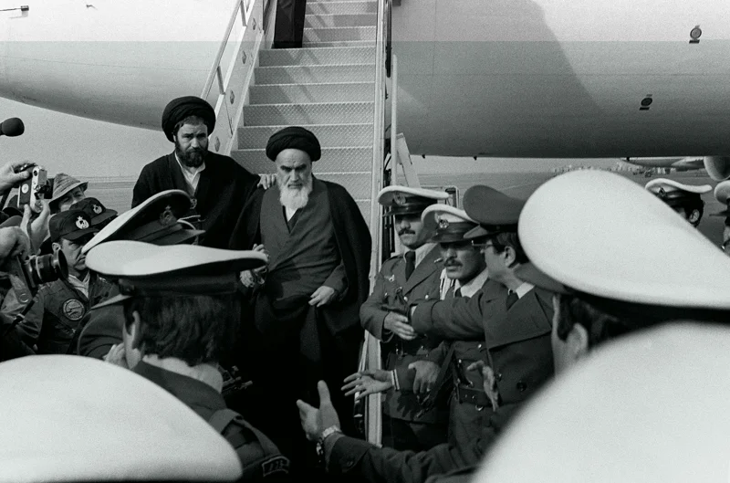โคไมนี ขณะกำลังลงจากเครื่องบินในกรุงเตหะรานเมื่อวันที่ 1 ก.พ. 1979 (ภาพจาก: Gabriel Duval/AFP)